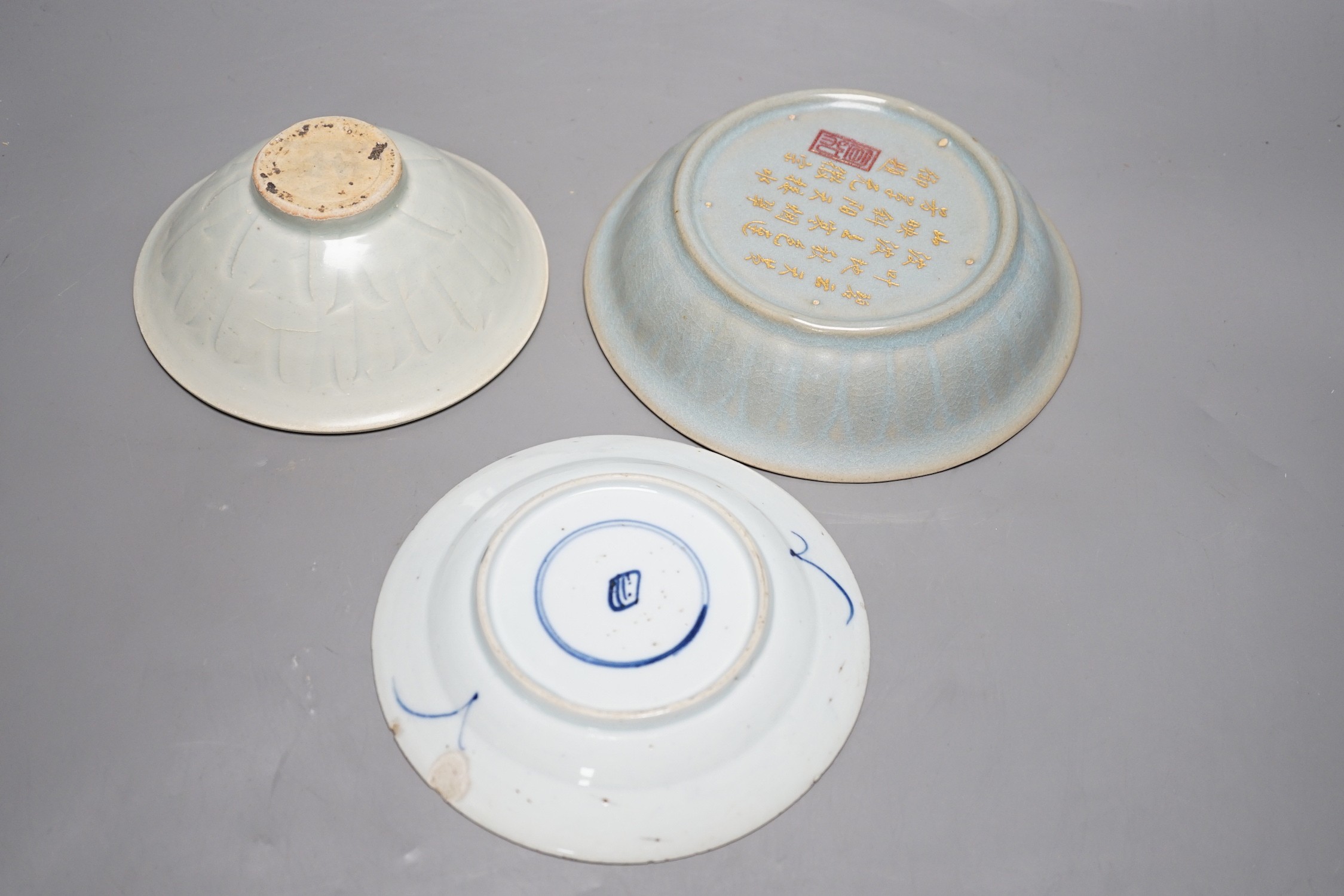A group of three Chinese ceramics; a Qing Bai style bowl, a Jun style bowl with dragon relief decor and inscription to base, and a blue and white dish, tallest 6cm
